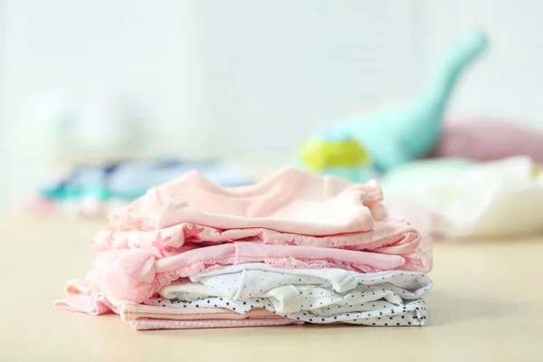 Σωρό από ρούχα του μωρού στο τραπέζι — Φωτογραφία Αρχείου