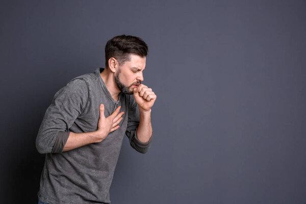 Mature man coughing on color background