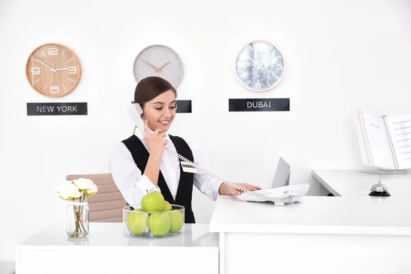 Recepcionista do sexo feminino falando ao telefone no local de trabalho no hotel — Fotografia de Stock