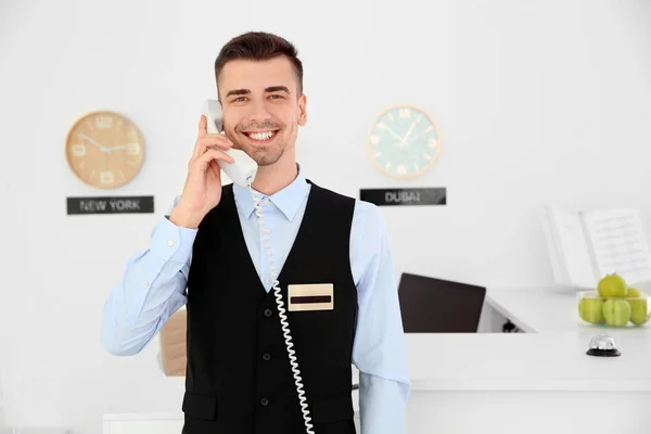 Resepsionis laki-laki berbicara di telepon di tempat kerja di hotel — Stok Foto