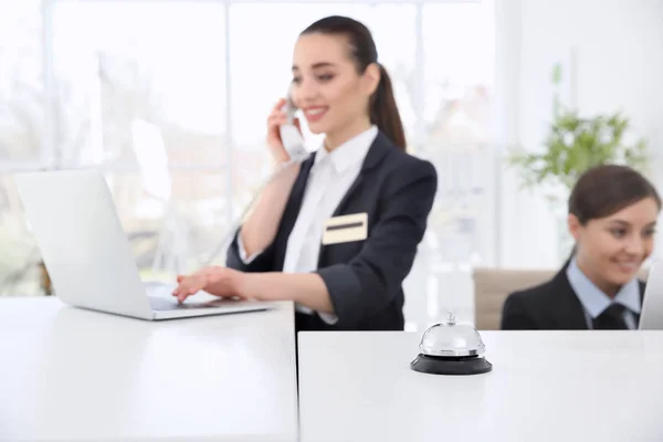 Service bell and female receptionists in hotel — Stock Photo, Image