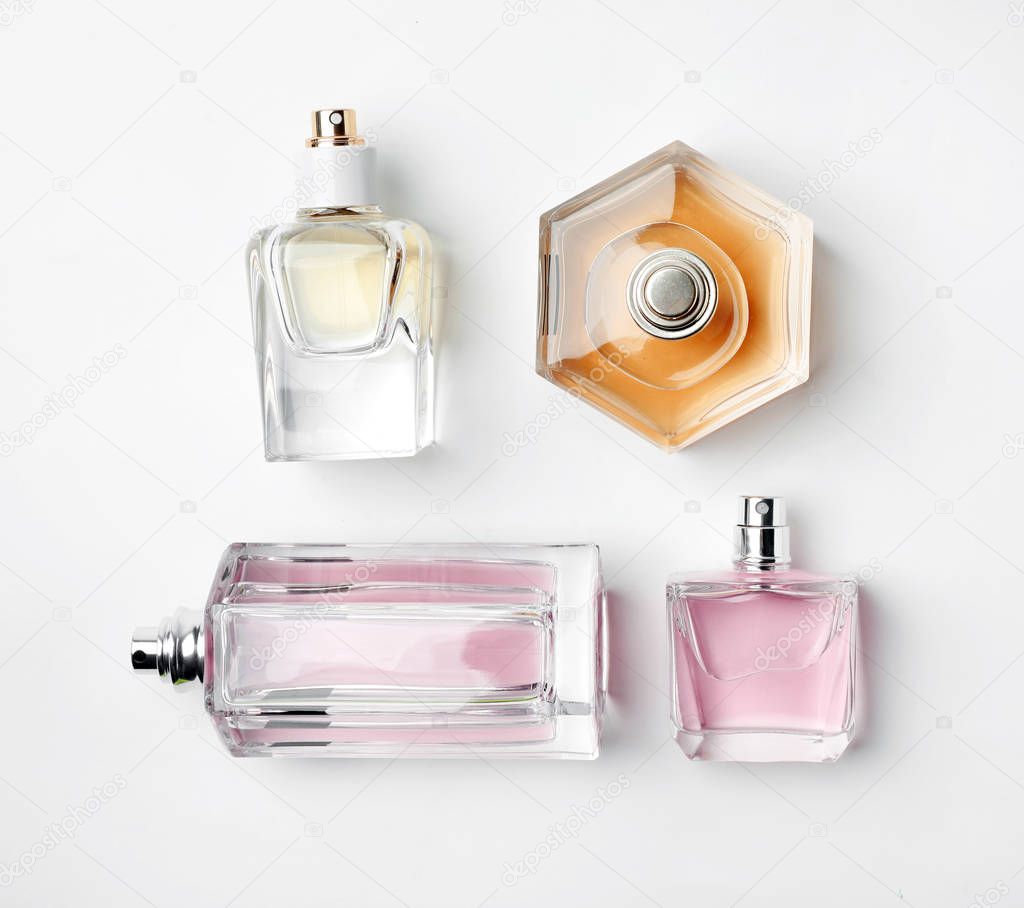Transparent bottles of perfume on white background