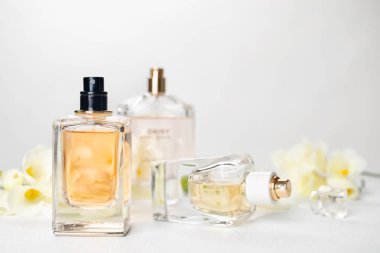 Parfüm şişeleri ve açık renkli karşı masaya çiçek
