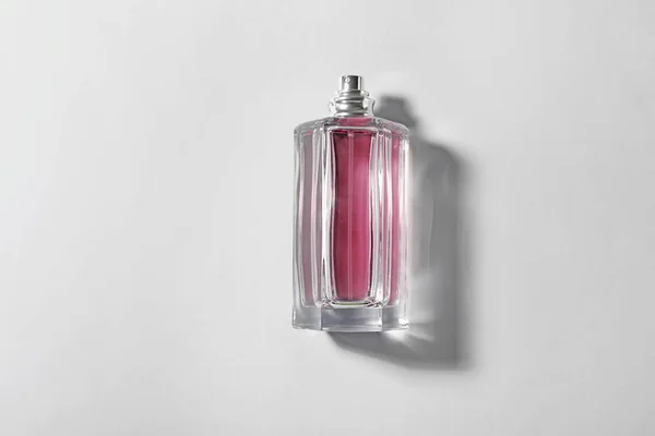 Botella de perfume sobre fondo claro, vista superior — Foto de Stock