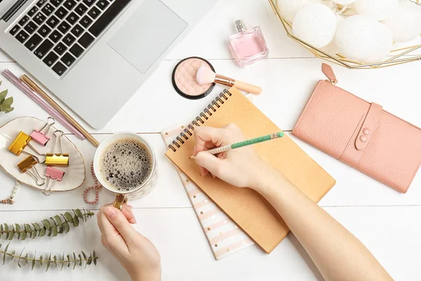 Woman with notebook, cosmetics and coffee on wooden background, flat lay. Beauty blogger — Stock Photo, Image