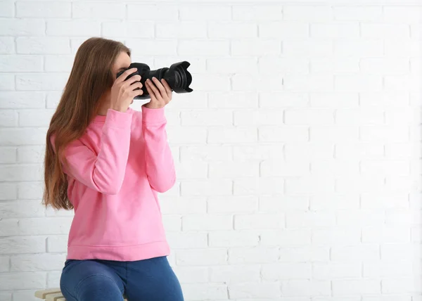 女摄影师与照相机在砖背景 — 图库照片