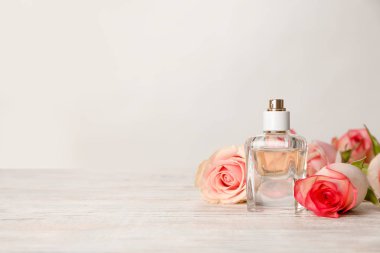 -Bir şişe parfüm ve açık renkli karşı masaya çiçek