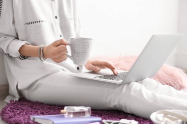 Dizüstü bilgisayar ve kahve kapalı kadın blogger