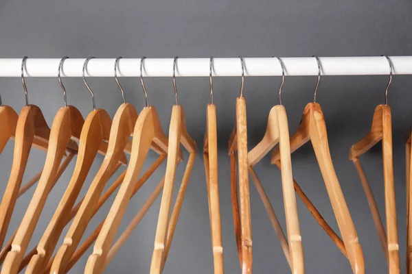 Porte-vêtements avec cintres en bois sur fond gris — Photo