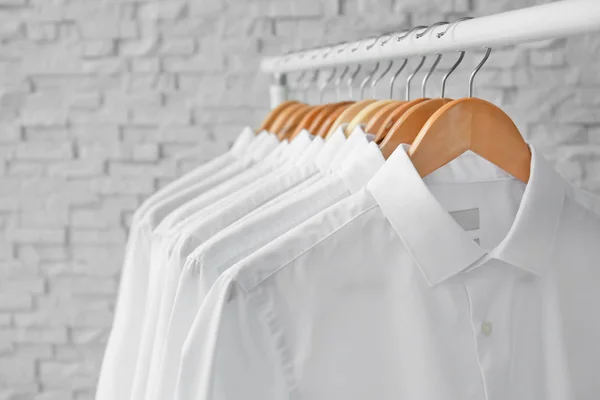 Rack with clean clothes on hangers after dry-cleaning indoors — Stock Photo, Image