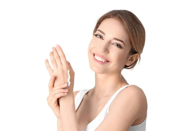 Mujer joven aplicando crema de manos sobre fondo blanco —  Fotos de Stock