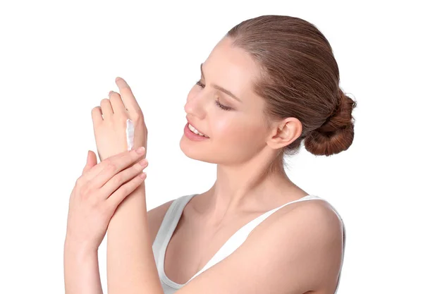 Mujer joven aplicando crema de manos sobre fondo blanco —  Fotos de Stock