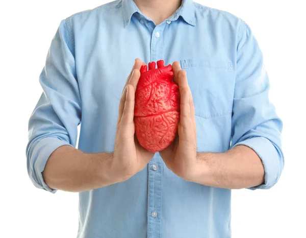 Hombre sosteniendo modelo de corazón sobre fondo blanco. Concepto de ataque cardíaco — Foto de Stock