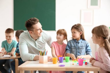 Okulda sınıfta öğretmen küçük sevimli çocukla