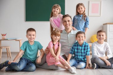 Okulda sınıfta öğretmen küçük sevimli çocukla