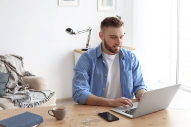 Laptop ile masa başında çalışan genç adam. Ev ofis