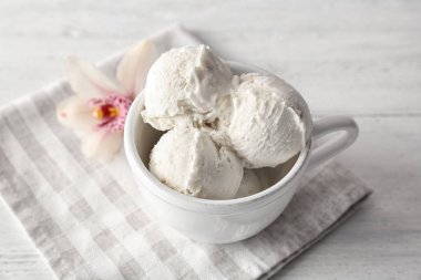 Kupası ahşap arka plan üzerinde lezzetli vanilyalı dondurma ile