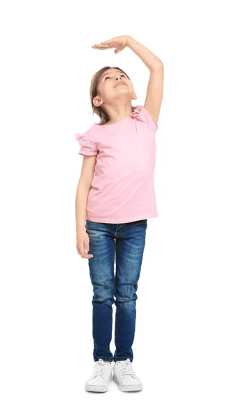 Little girl measuring her height on white background — Stock Photo, Image