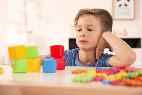 Маленький мальчик-аутист играет с кубиками дома — стоковое фото