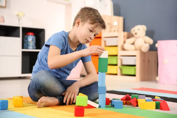 Kleiner autistischer Junge spielt zu Hause mit Würfeln — Stockfoto