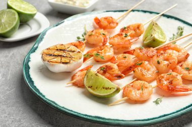 Lezzetli kızarmış karides şiş şifreli ve kireç gri arka planda, closeup ile plaka