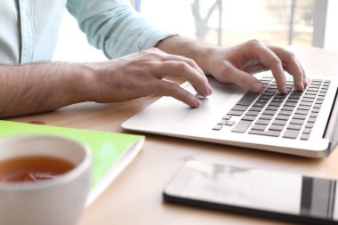 Laptop ile masa başında çalışan genç adam. Ev ofis