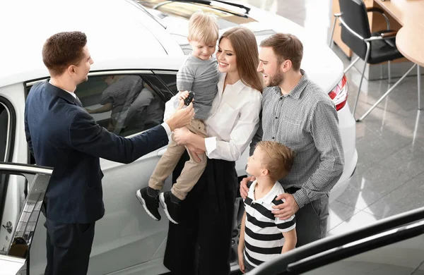 Verkoper Geven Sleutel Tot Jonge Familie Auto Salon — Stockfoto