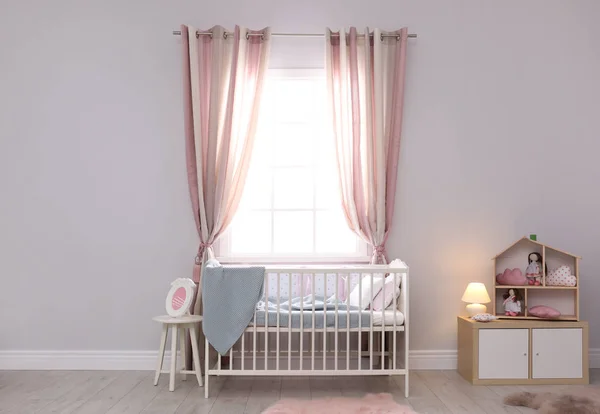 Baby room interior with comfortable crib and dollhouse — Stock Photo, Image