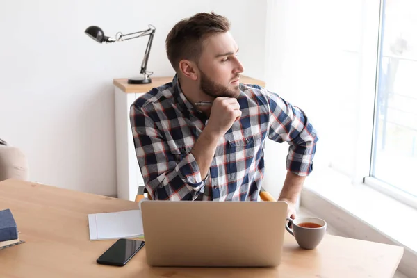 Jeune homme travaillant avec un ordinateur portable au bureau. Bureau à domicile — Photo
