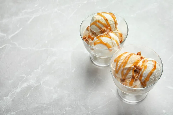 Ciotole con gelato al caramello su fondo chiaro — Foto Stock