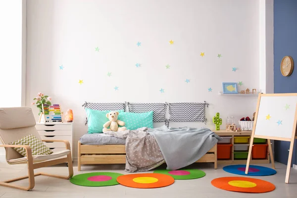 Quarto infantil moderno interior com cama confortável e poltrona — Fotografia de Stock