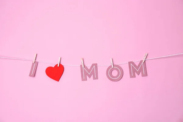 Satz "i love mom" aus Papierbuchstaben, die vor farbigem Hintergrund am Seil hängen. Glücklicher Muttertag — Stockfoto