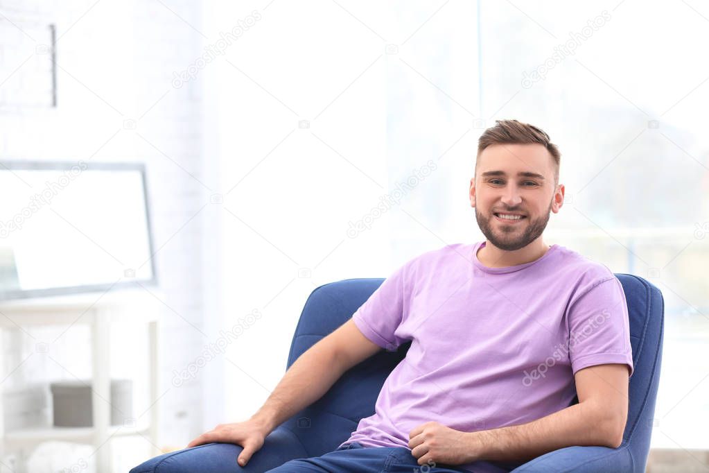 Portrait of confident young man in armchair