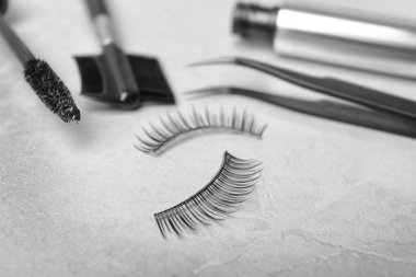 Sahte kirpik ve gri arka plan, closeup kozmetik Araçlar