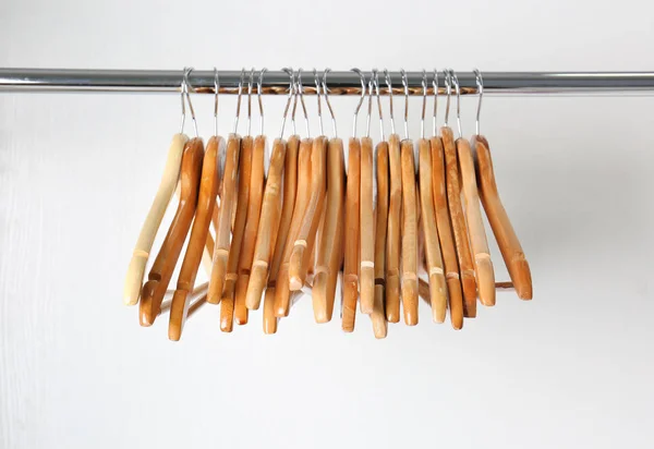 Перила одежды с деревянными вешалками на белом фоне — стоковое фото