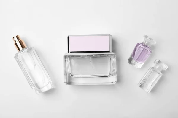 Flacons transparents de parfum sur fond blanc — Photo