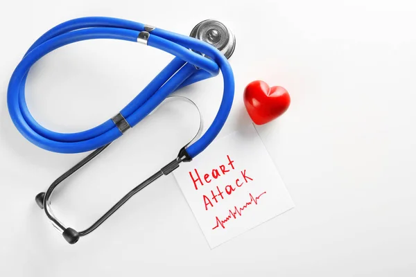 听诊器, 笔记与词组 "心脏病发作" 和小红色心脏在轻的背景下 — 图库照片