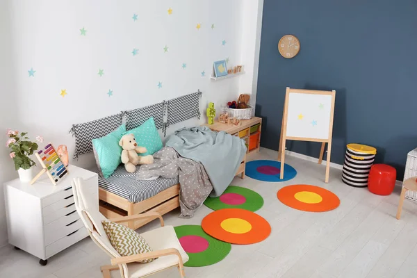 Moderne Kinderzimmereinrichtung mit bequemem Bett und Sessel — Stockfoto