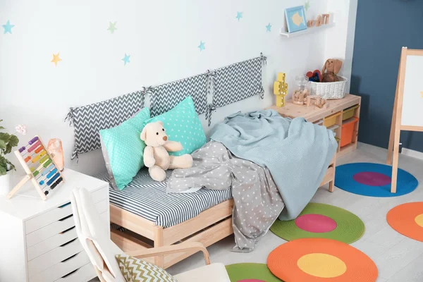 Moderno interior de la habitación infantil con cómoda cama y sillón —  Fotos de Stock