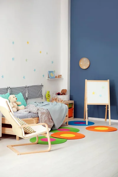 Modern child room interior with comfortable bed and armchair Royalty Free Stock Photos