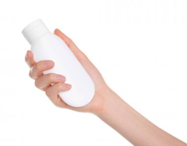 Beyaz arka plan üzerinde el kremi ile şişe tutan genç kadın