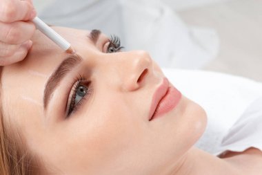 Genç kadın kaş kalıcı makyaj yordamı için closeup hazırlanıyor güzellik uzmanı