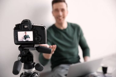 Erkek blogger ile laptop yakınındaki hafif duvar, closeup fotoğraf makinesi ekranında