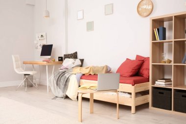 Rahat yatak ve modern çocuk odası içinde laptop ile tablo