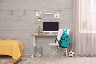 Çocuk odasında modern bilgisayar ile rahat çalışma alanı