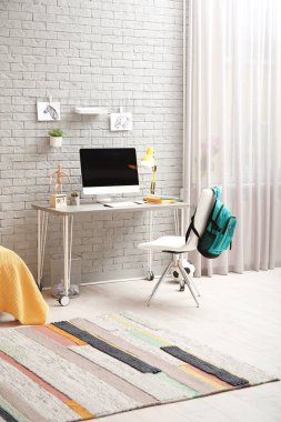 Çocuk odasında modern bilgisayar ile rahat çalışma alanı