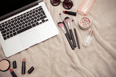Kumaş üzerine kadın için laptop ve makyaj ürünleri ile düz yatıyordu kompozisyon