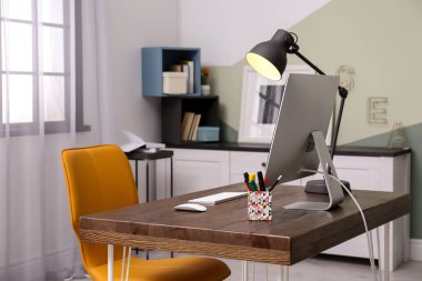 Ev ofisindeki masada bilgisayarla rahat bir iş yeri.