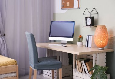 Ev ofisindeki masada bilgisayarla rahat bir iş yeri.