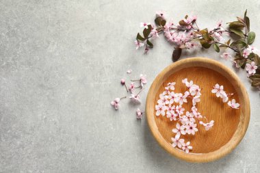 Su ve gri arka plan üzerinde çiçek çiçekler ile kase